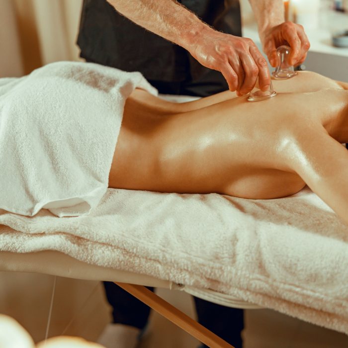 professional male therapist doing vacuum massage with the special cups chinese massage